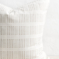 3: A natural cotton throw pillow with embroidered basketweave pattern in brown.