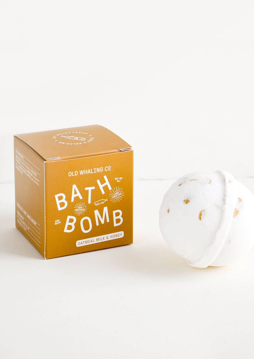 Oatmeal Milk & Honey: White colored, round bath bomb with brown box packaging