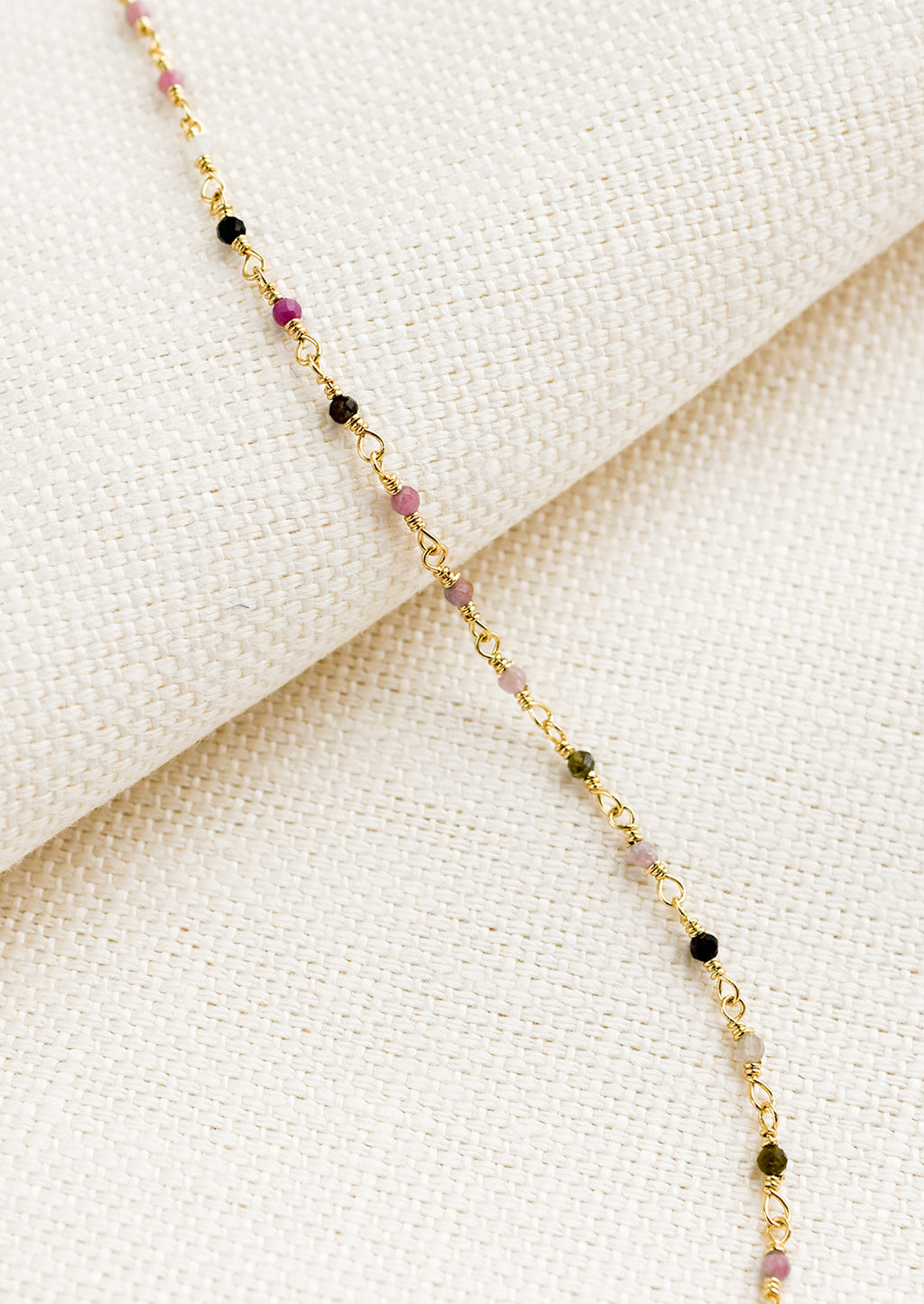 1: A gold wire bracelet with small multicolor tourmaline beads.
