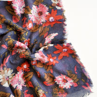 2: Close up shot of scarf with dark blue background and multi-colored pink and red floral pattern 