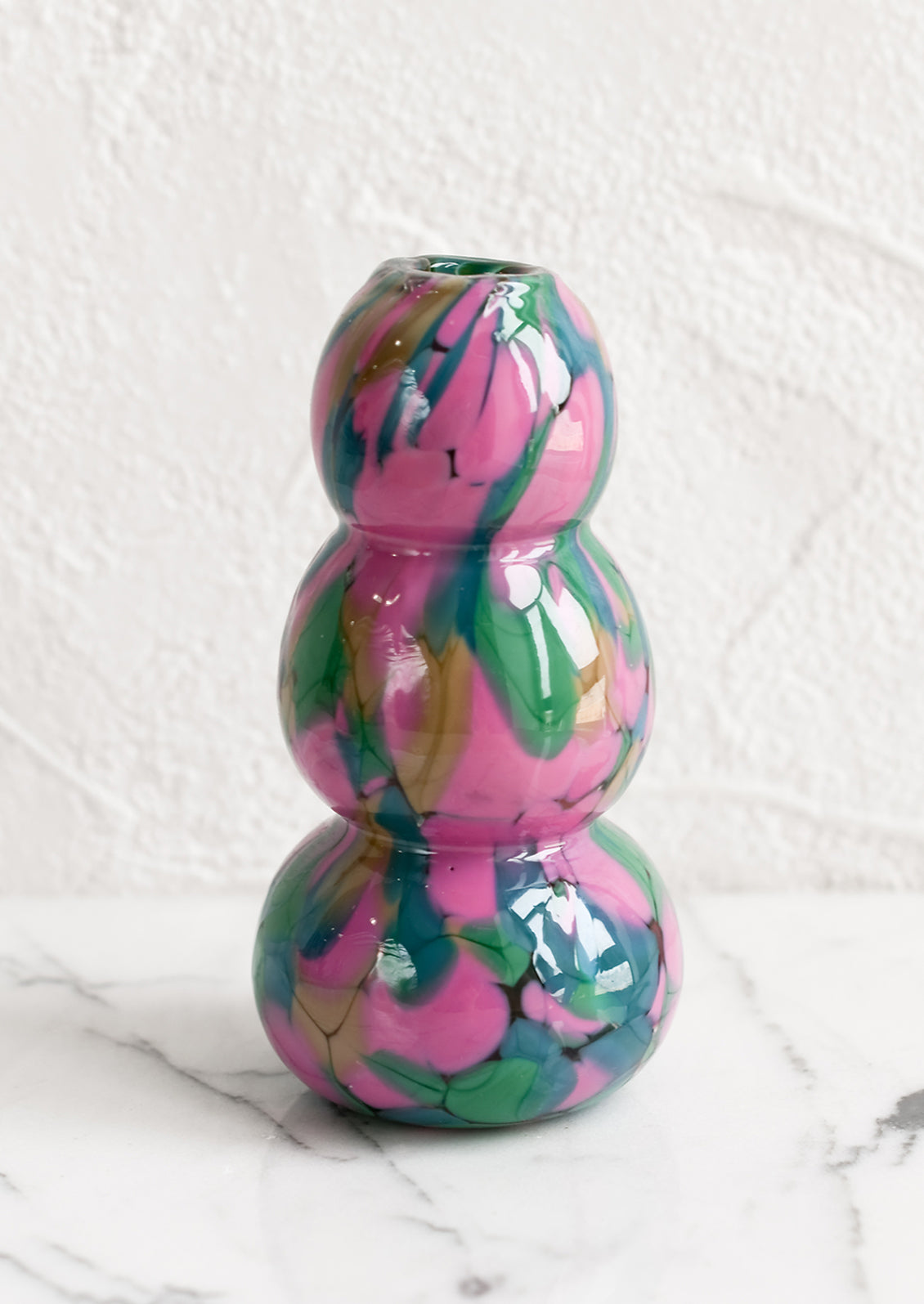 A speckled glass vase in pink, teal and green palette.
