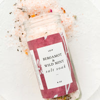Bergamot & Wild Mint: Bergamot and wild mint bath salt soak spilling out of a glass jar.