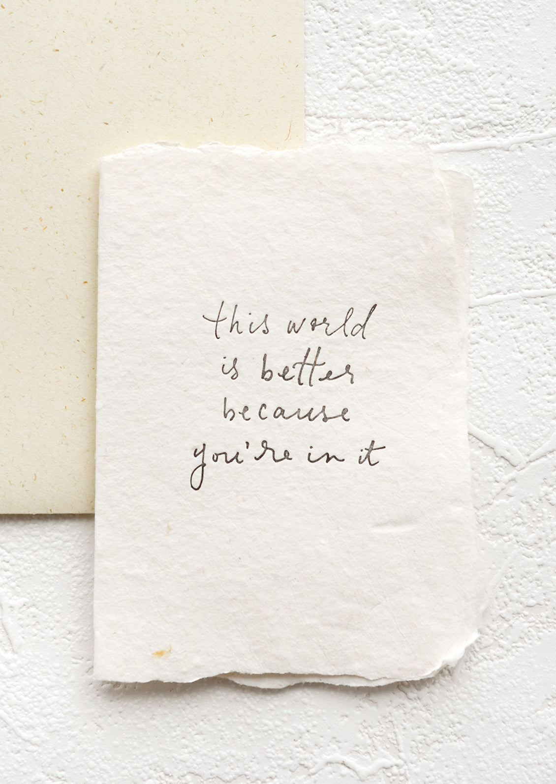 A greeting card with text reading "this world is better because you're in it".
