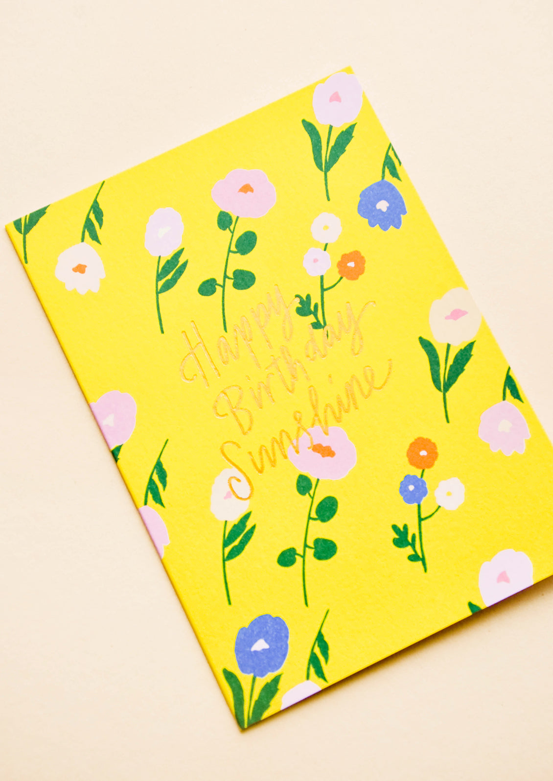 Greeting card in sunny yellow with flowers and "Happy Birthday Sunshine" in gold text