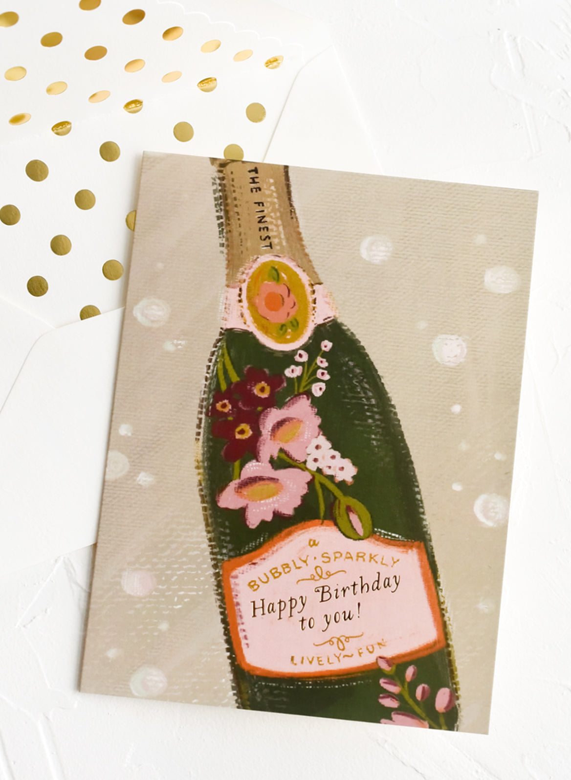 A greeting card with illustration of champagne bottle reading "Happy birthday to you!'.