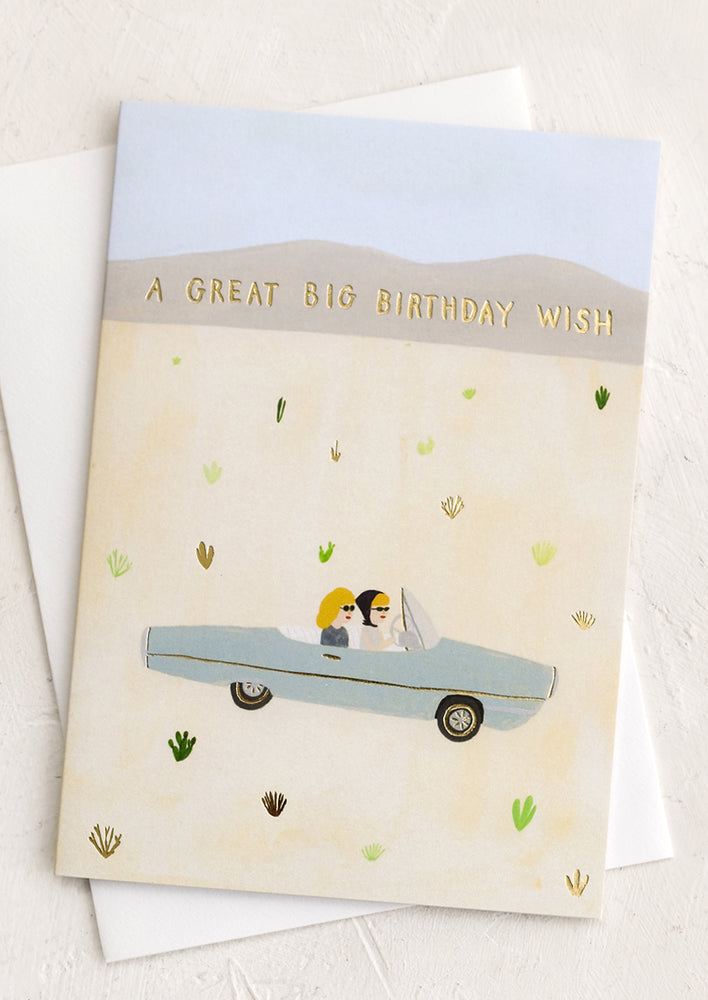 A greeting card with illustration of two women driving through the desert.