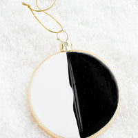 2: A decorative holiday ornament in the shape of a black & white cookie.