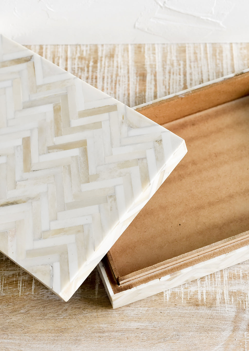 2: A rectangular storage box in cream colored herringbone pattern.