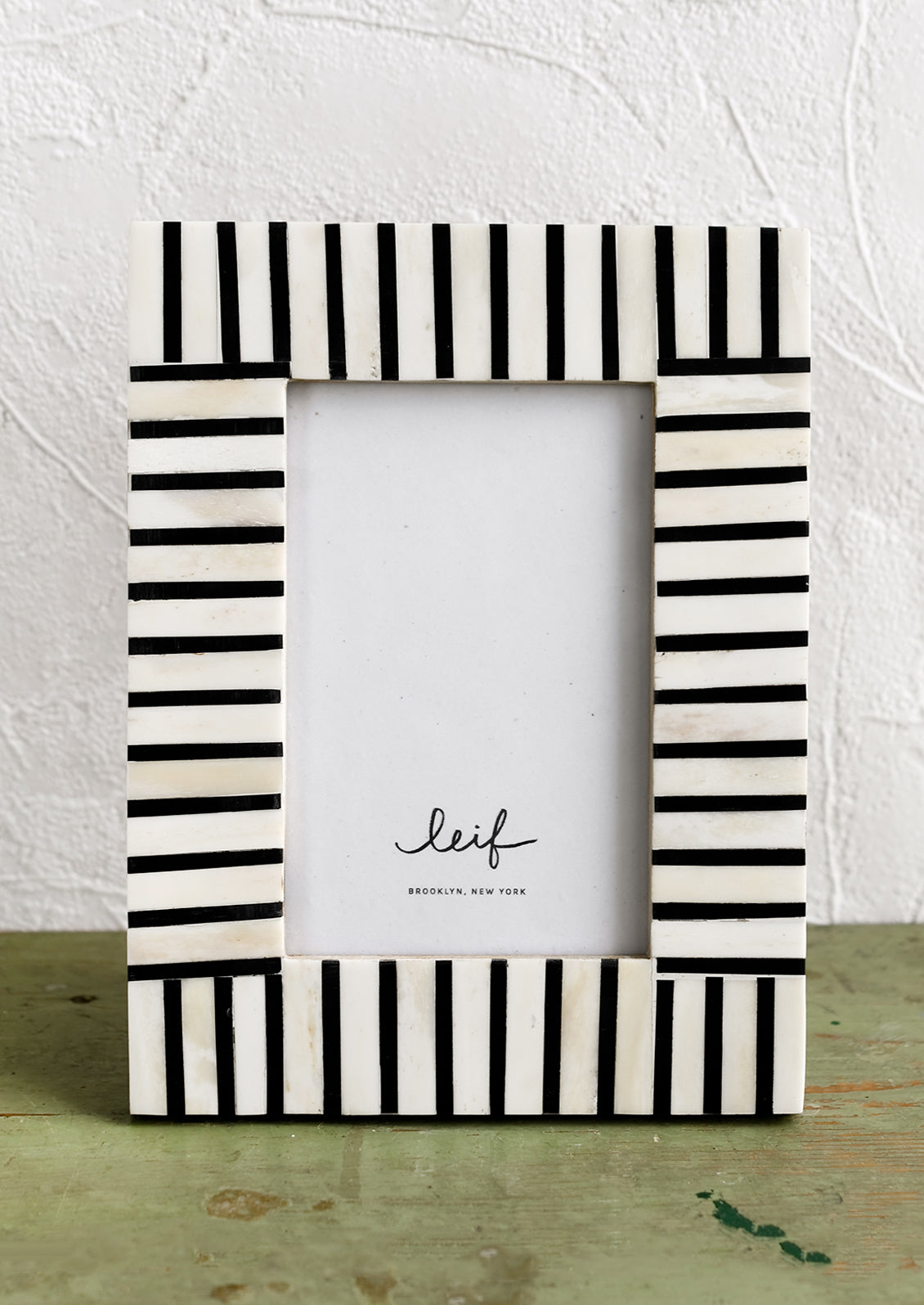 A black and white picture frame with alternating stripe pattern.