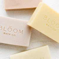 1: Four rectangular bars of soap in pastel colors with logo imprint.