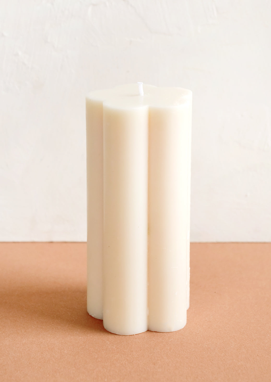 A flower shaped pillar candle in off white.