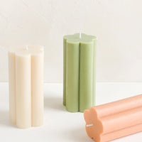 Sage: Three flower shaped pillar candles in assorted colors.