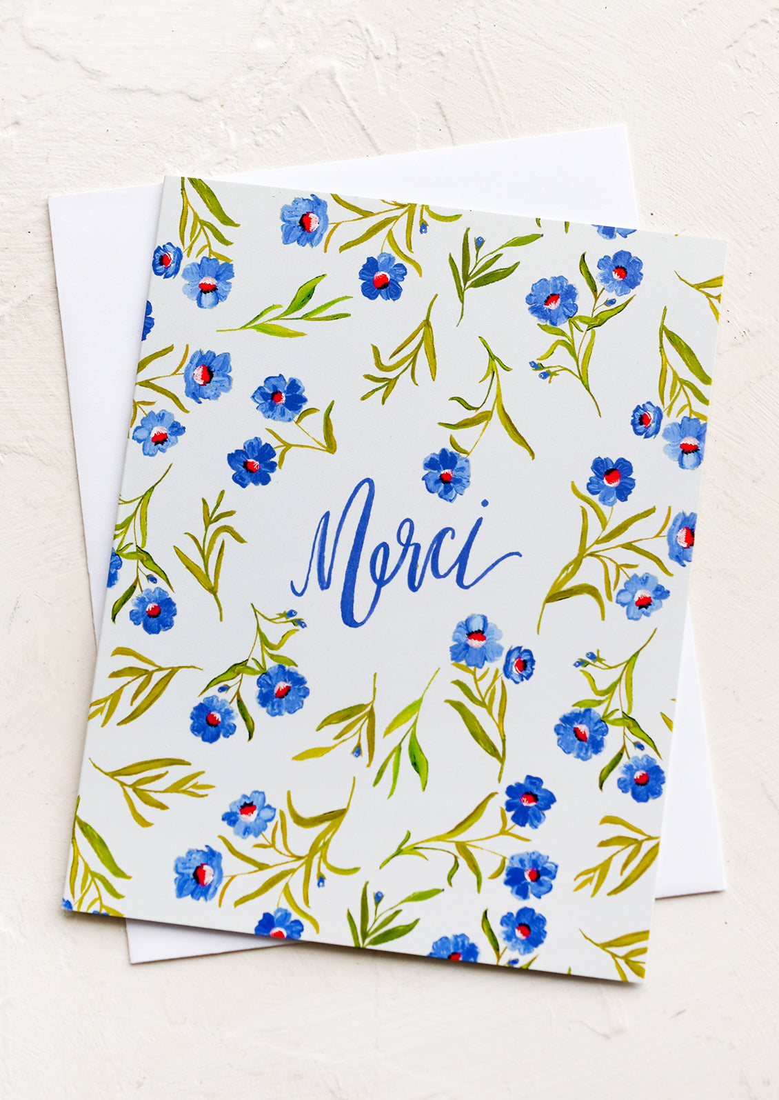 A floral print card with "Merci" in cursive.