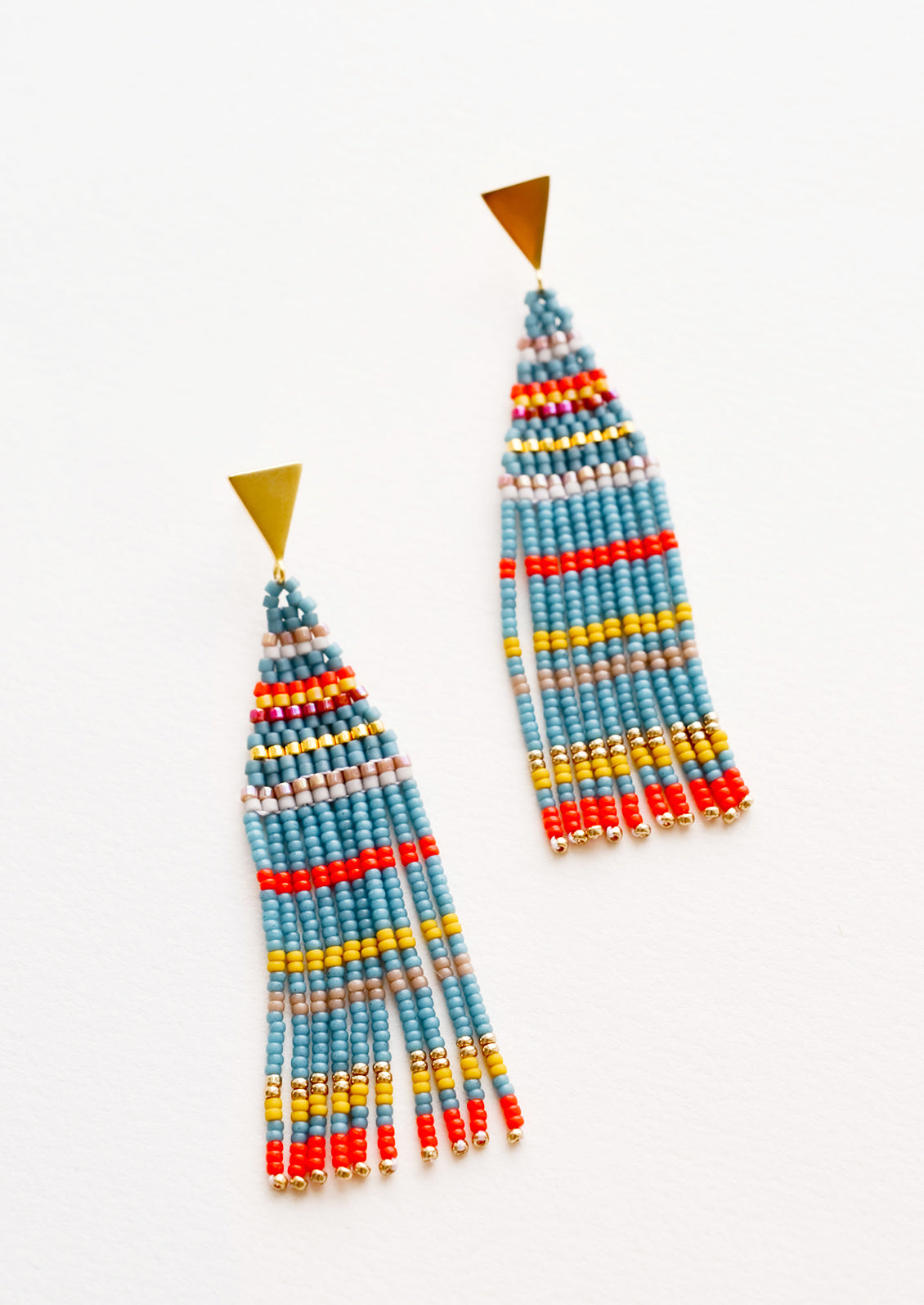 Fringe beaded earrings in blue with yellow, orange, and gold horizontal stripes on a triangular gold post.