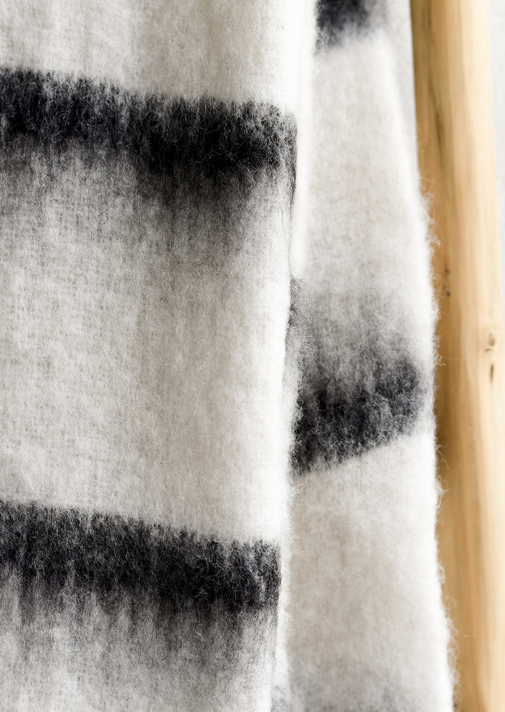2: A fuzzy throw blanket in white with black stripes.