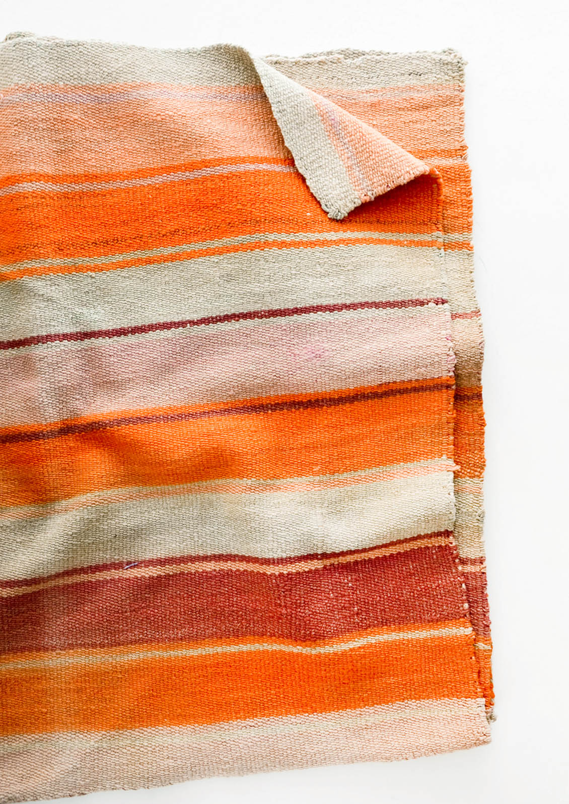 Woven textile intended for use as a rug or blanket, variegated colorful striped pattern.