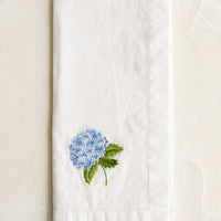 Hydrangea: A white cotton napkin with blue hydrangea embroidery.