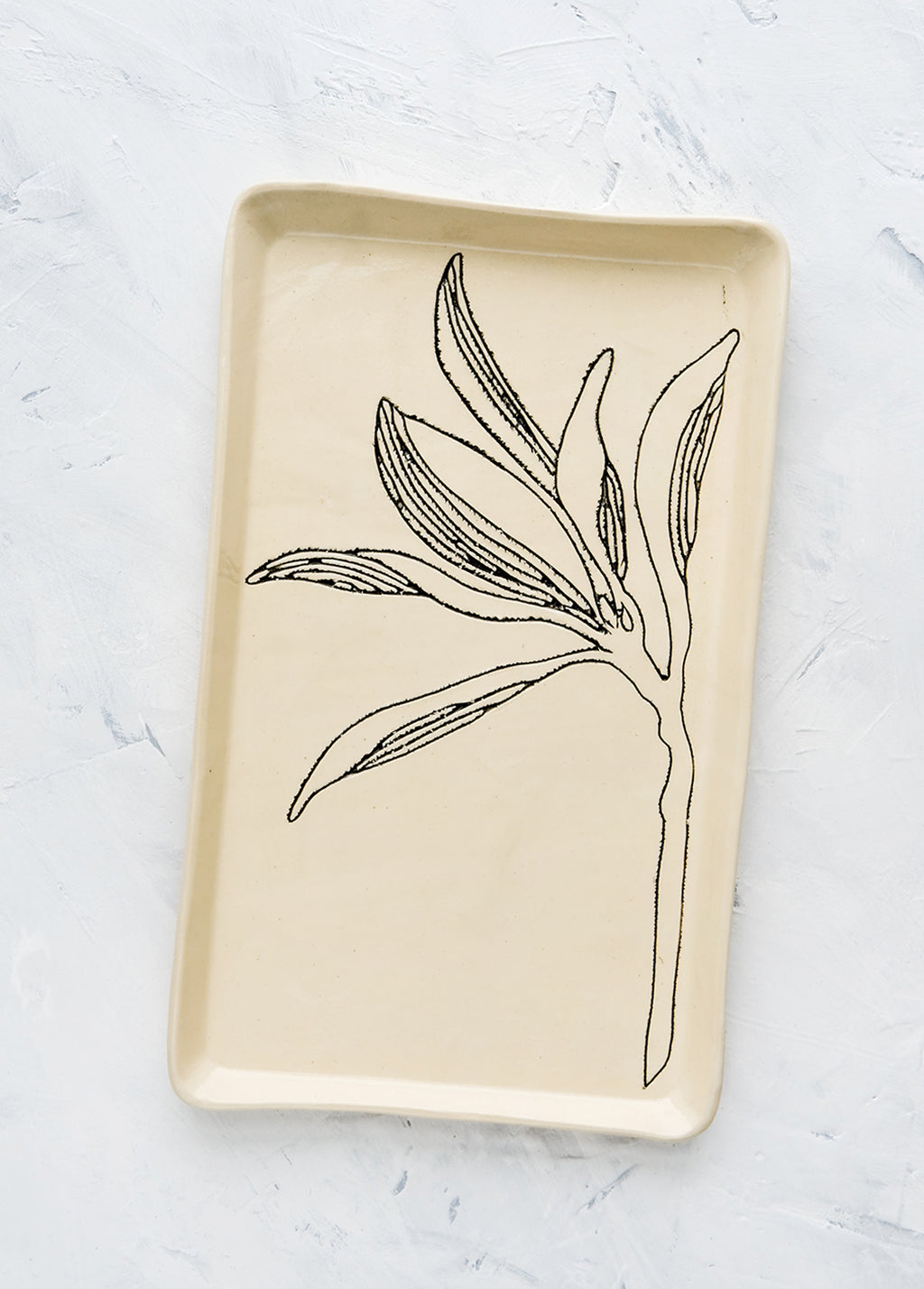 Magnolia: A rectangular ceramic tray in natural bisque color with an etched black drawing of a Magnolia branch.
