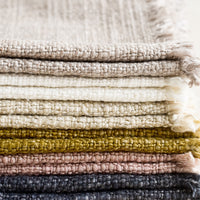 2: A stack of slub boucle textured placemats in assorted colors.