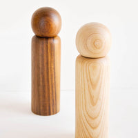 1: Two minimal Wooden Salt & Pepper Grinders with Spherical Tops in dark and light wood.