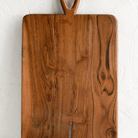 1: A rectangular cutting board with loop handle at top and bowtie inlay detailing.