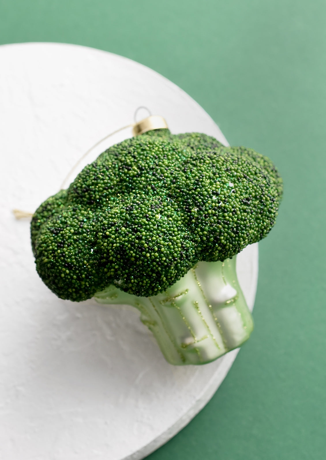 A decorative holiday ornament in shape of head of broccoli.