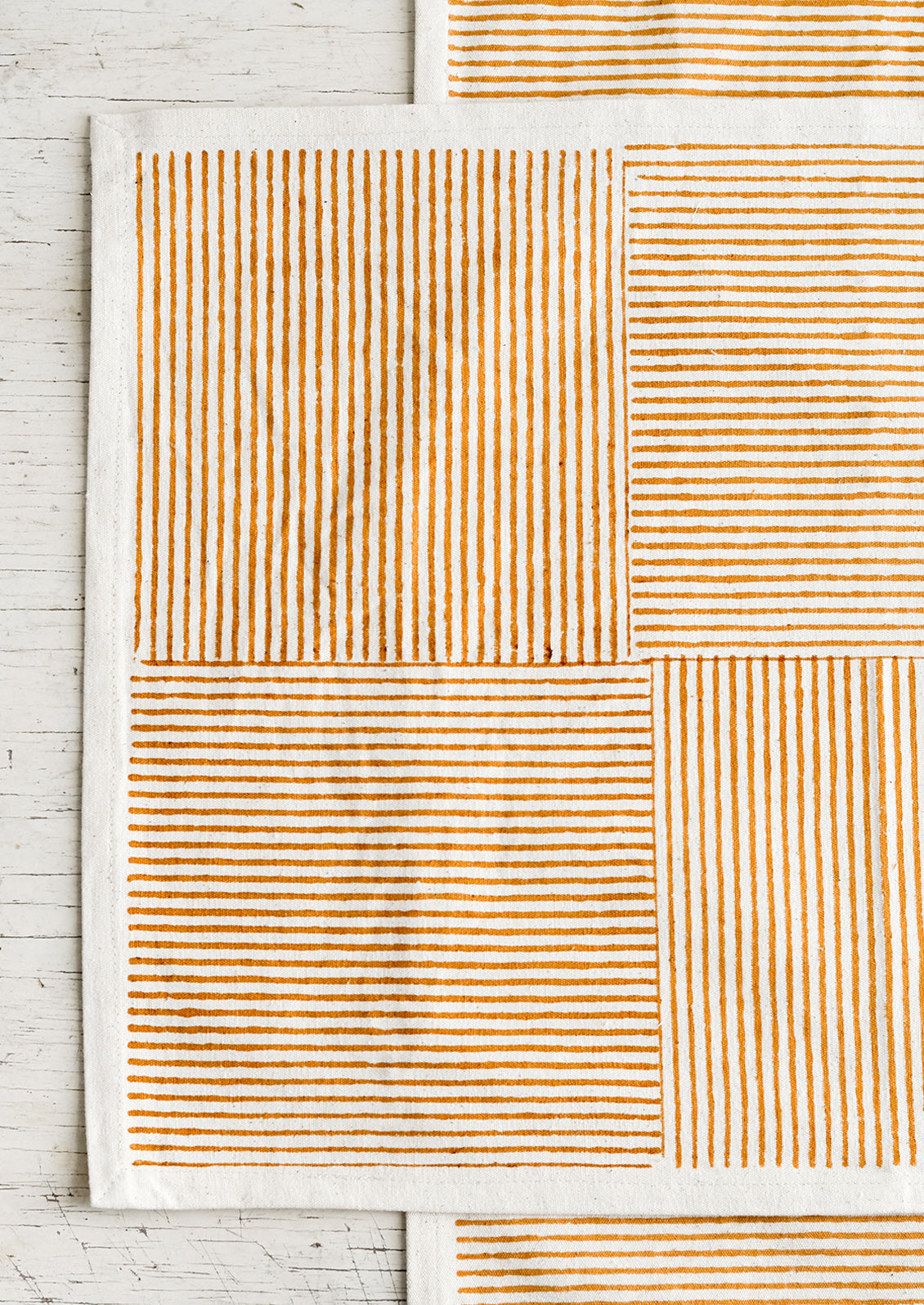 Block printed cotton placemats with boxed stripe pattern in ochre.