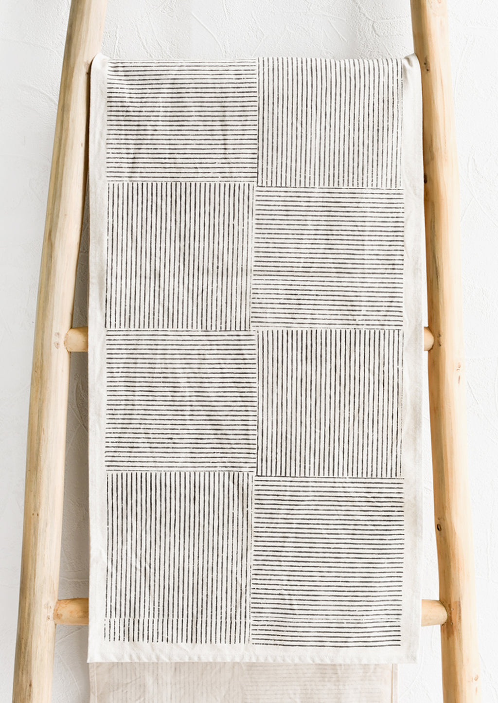 1: A natural cotton table runner with black broken stripe block print.