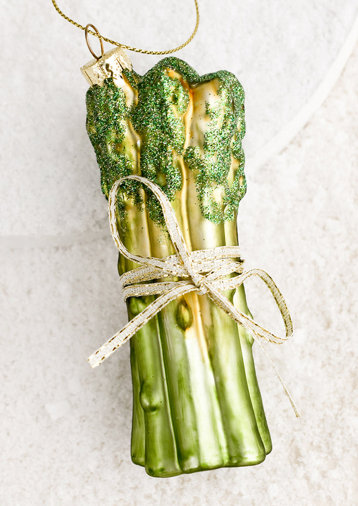A holiday ornament of asparagus spears tied with ribbon.