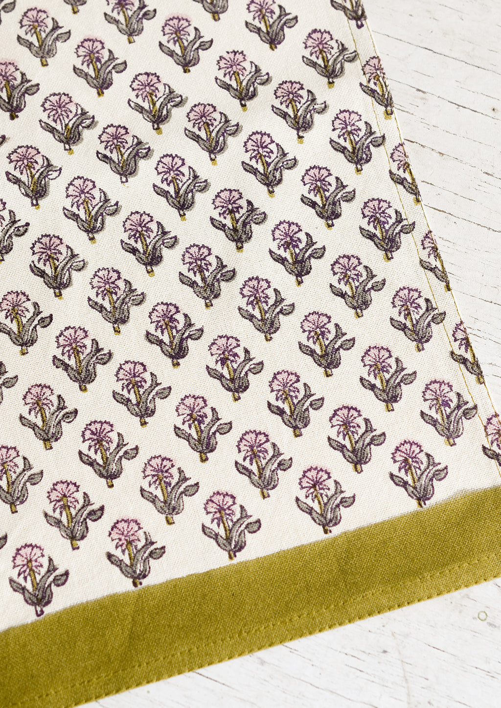 Crocus Multi: A tea towel with pink floral print and olive trim.