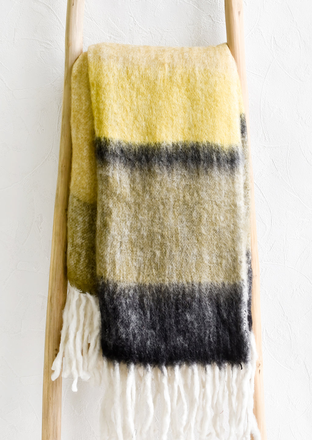 Dune Multi: A striped mohair throw blanket in tones of yellow and black.