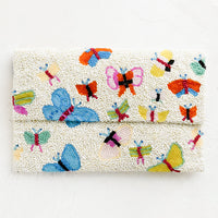 1: A white beaded clutch with front foldover flap, with multicolor butterfly design.