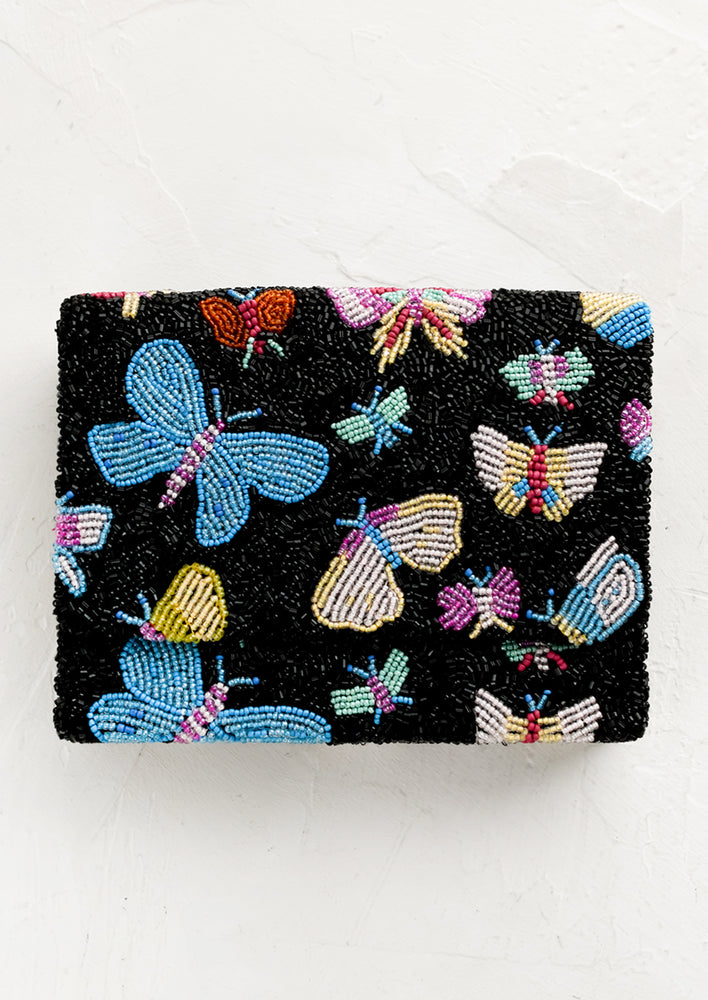 A black beaded box-shaped clutch with multicolor butterfly design.
