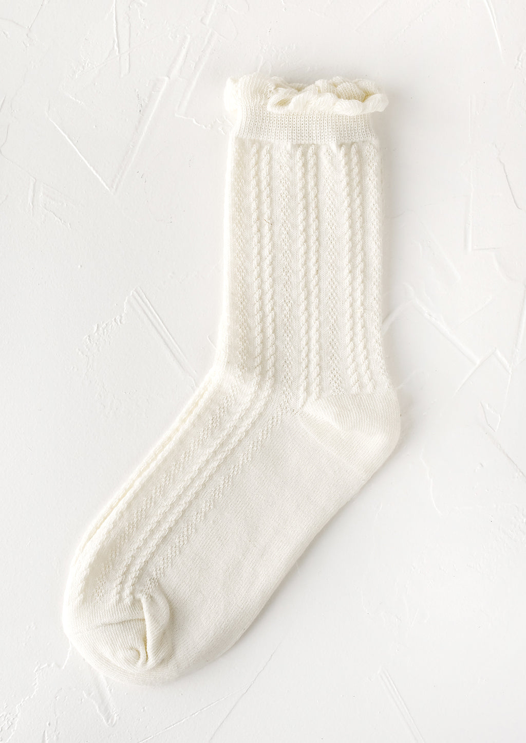 White: A pair of cable knit socks with ruffled ankle in white.