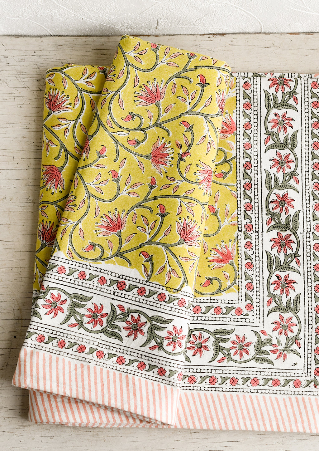 1: A block printed tablecloth in yellow, pink and green floral.
