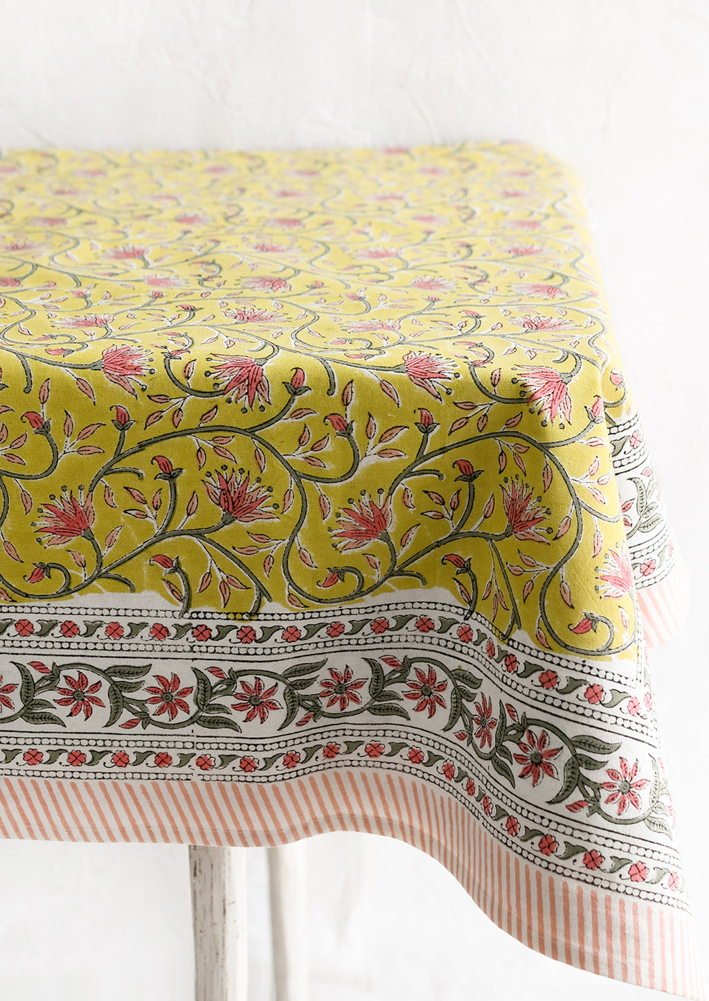 2: A block printed tablecloth in yellow, pink and green floral.