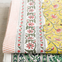 3: A block printed tablecloth in yellow, pink and green floral.