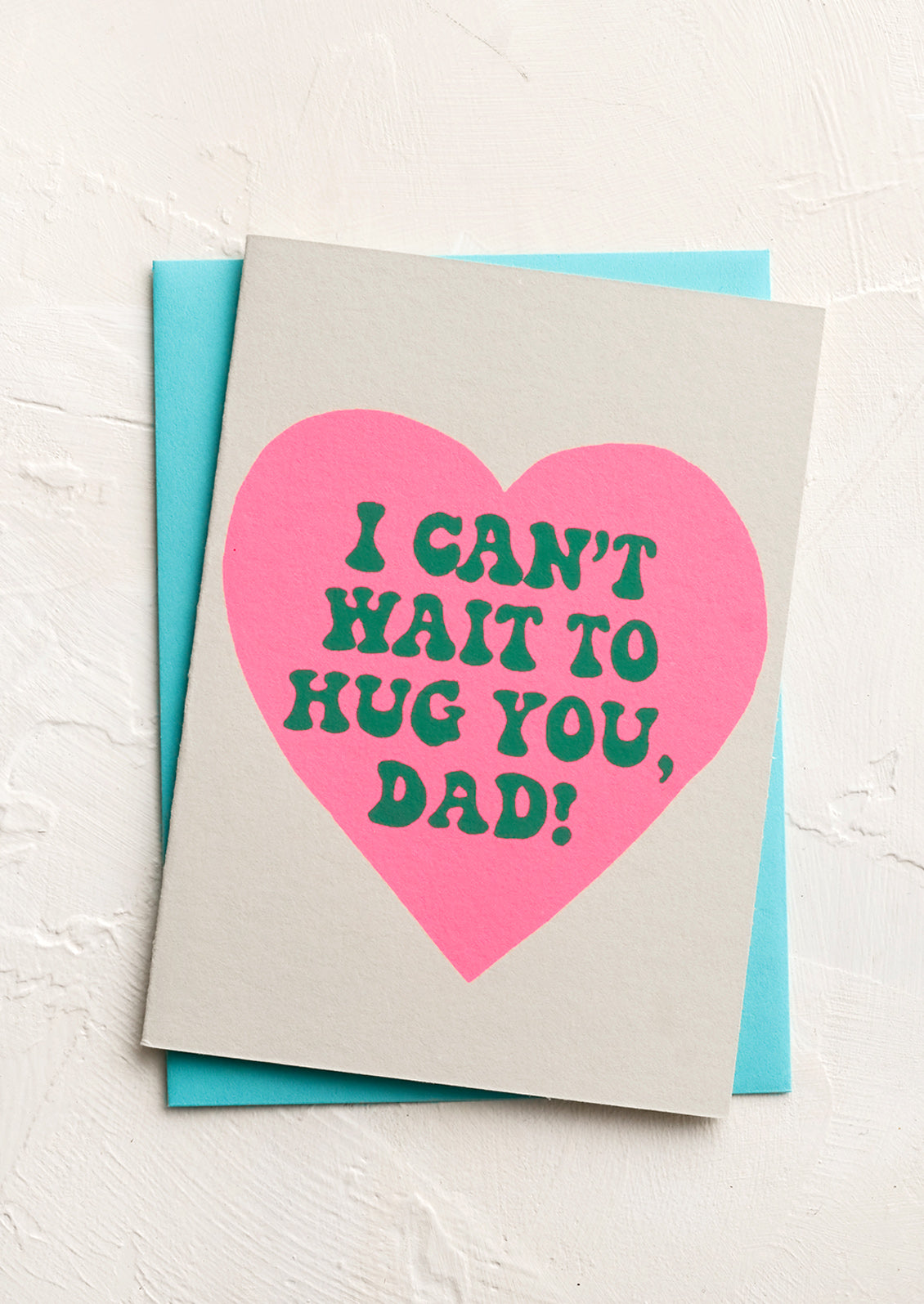 A greeting card with text inside pink heart reading "Can't wait to hug you dad"