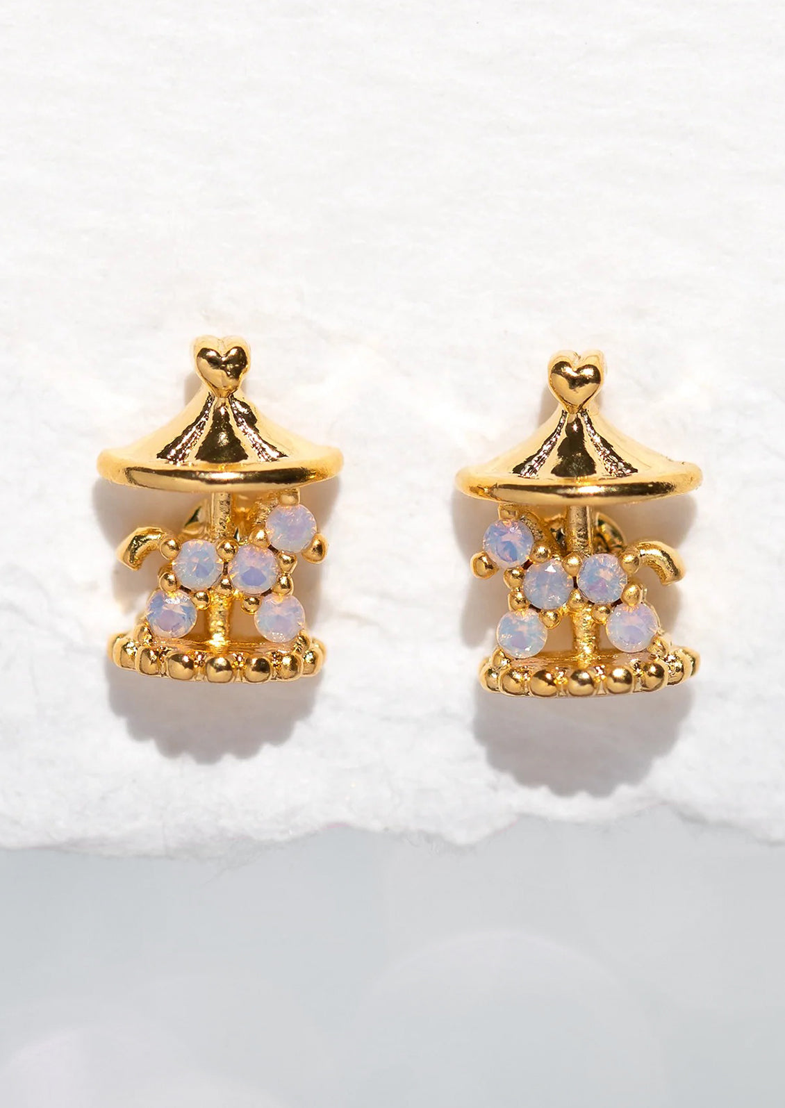 A pair of gold stud earrings in shape of carousel.