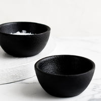1: Two small cast iron pinch bowls, one holding salt.
