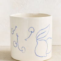 1: An ivory ceramic planter with fruit line drawings in blue.