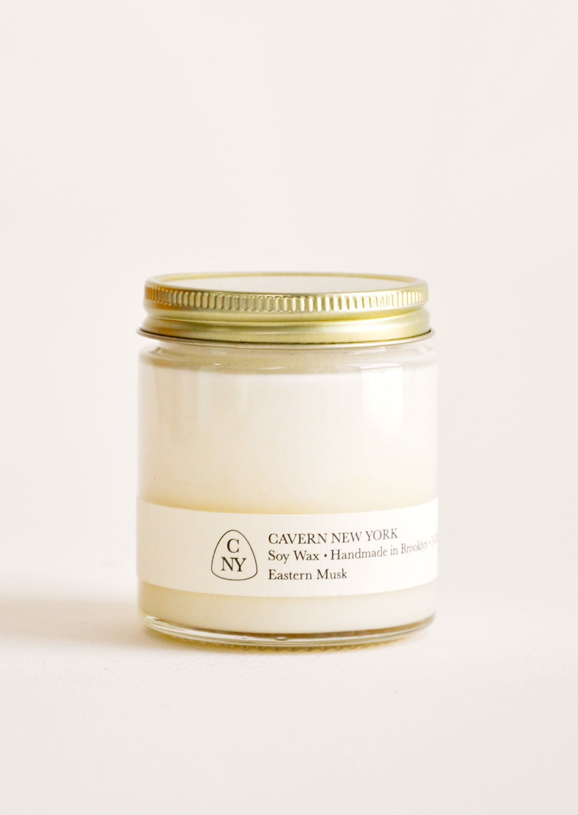 Glass jar with gold lid and white label.