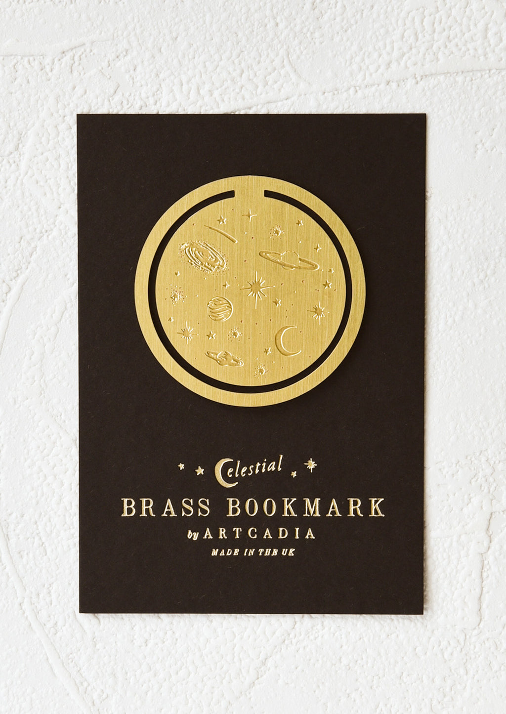 Celestial: A circular brass bookmark with etched celestial pattern.