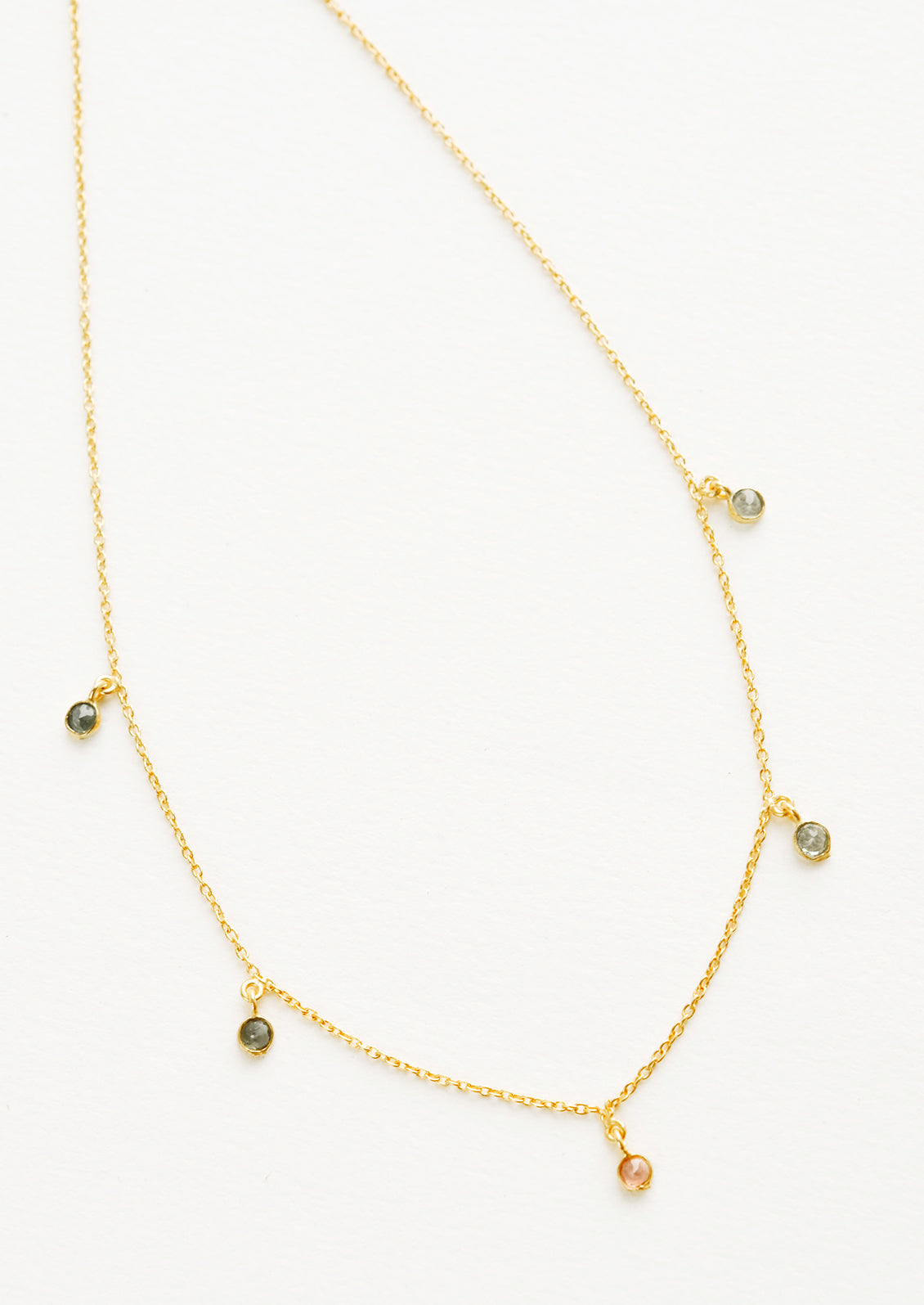 Yellow gold chain necklace with 5 small dangling multicolored gemstones.