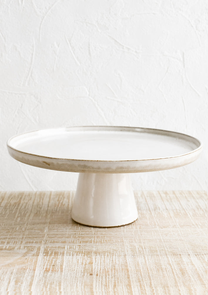 1: A round, footed ceramic cake stand.