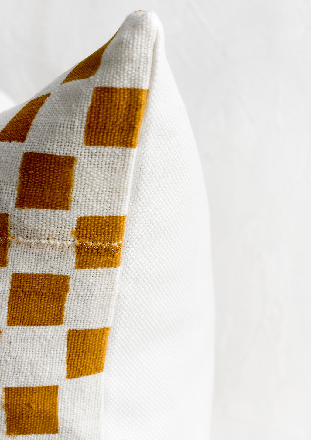 3: A checkered throw pillow with white linen back.
