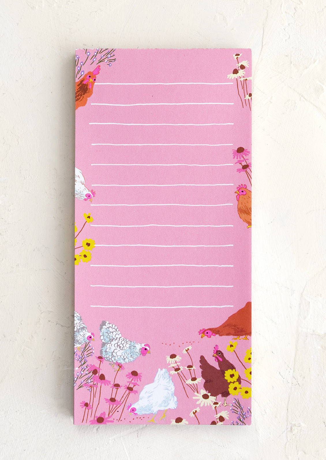 A ruled pink notepad with chicken print.