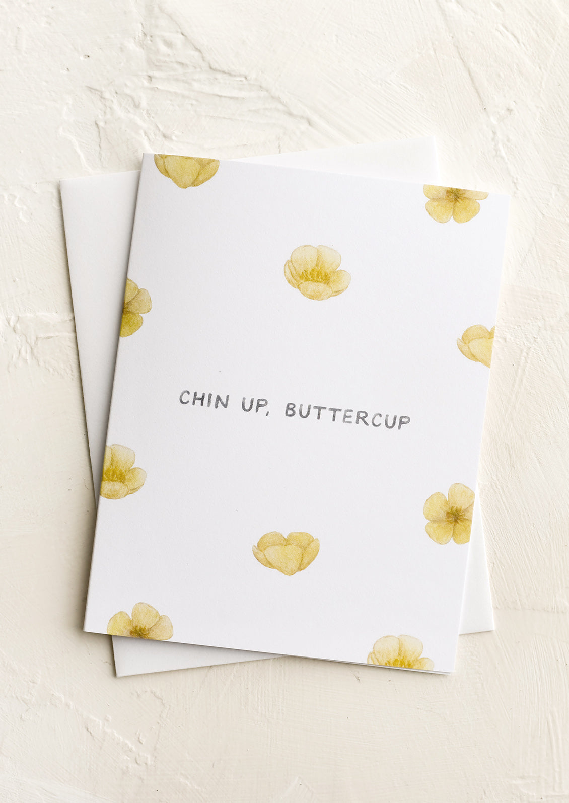 A greeting card with images of buttercups, text reads "chin up buttercup".