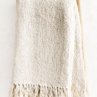 1: An ivory colored cotton throw with chunky boucle texture.