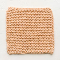 Nougat: A square, chunky knit cotton potholder in soft peach color.
